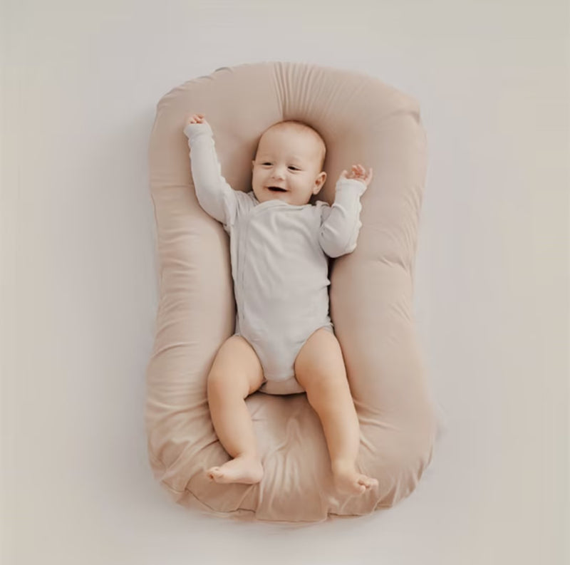 Almohada nido para bebé ovalada con borde acolchado elevado